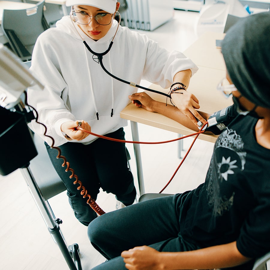 Exercise & Health Sciences student takes blood pressure of another student