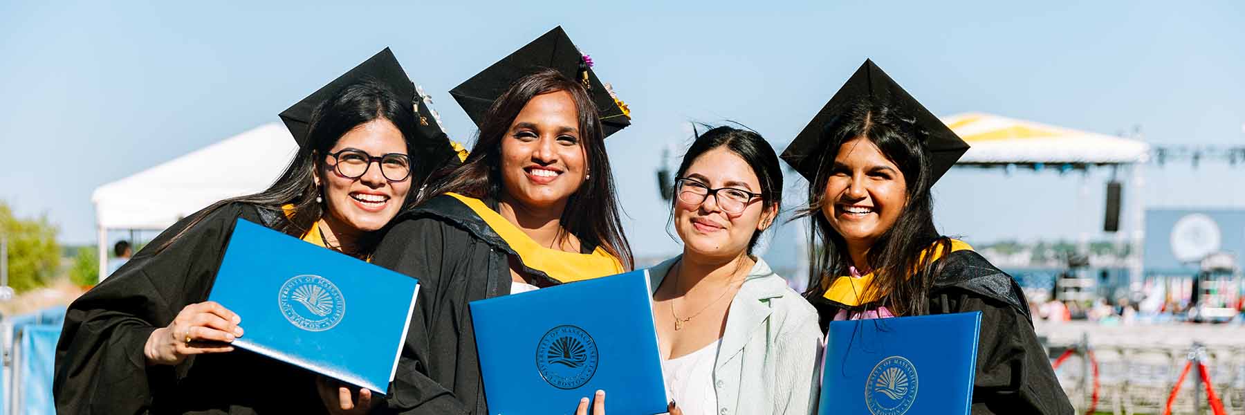 Four students pose for a photo at graduation.